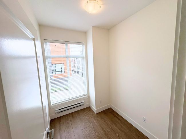 Unfurnished room with a baseboard heating unit, wood finished floors, and plenty of natural light | Image 8