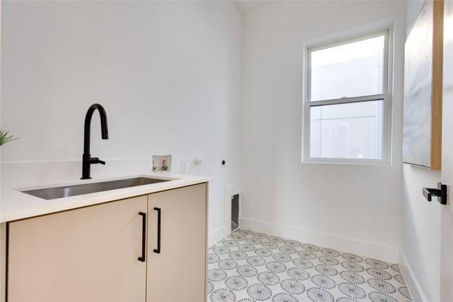 Laundry room featuring electric dryer hookup, sink, washer hookup, and cabinets | Image 34