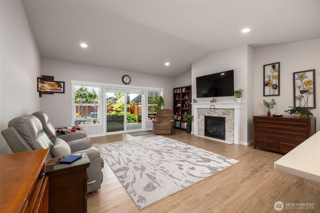 The great room has a gas fireplace, TV prep over fireplace and lots of glass/light from the slider and window wall. | Image 18