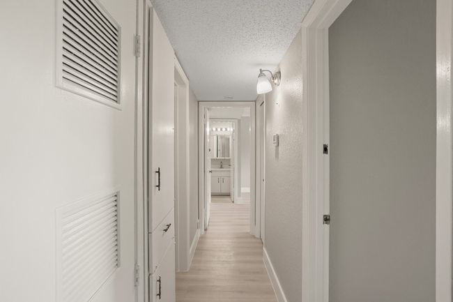 Hall featuring a textured ceiling and light wood-style floors | Image 17