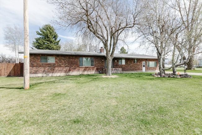 View of front of property with a front yard, crawl space, fence, and a chimney | Image 44