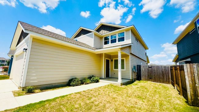 View of front of home with board and batten siding, a fenced backyard, a garage, and a gate | Image 4