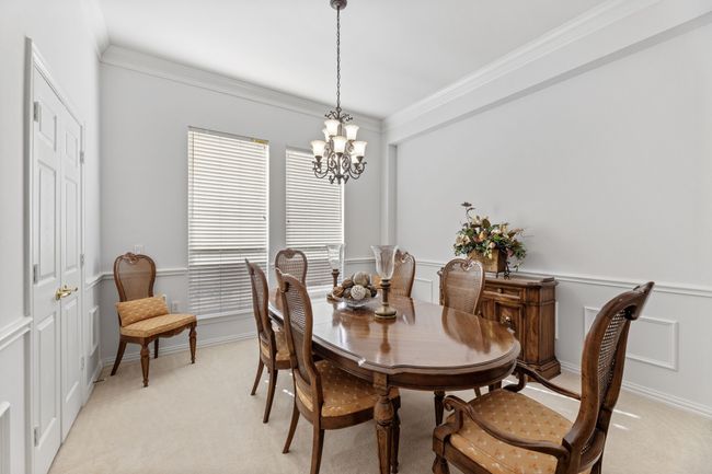 Carpeted dining room featuring ornamental molding and a chandelier | Image 10