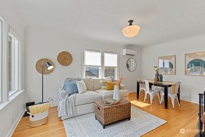 Beautiful and bright living room with top down bottom up shades, original hardwood floors, wood burning fireplace, and a mini split for those hot summer days. | Image 3