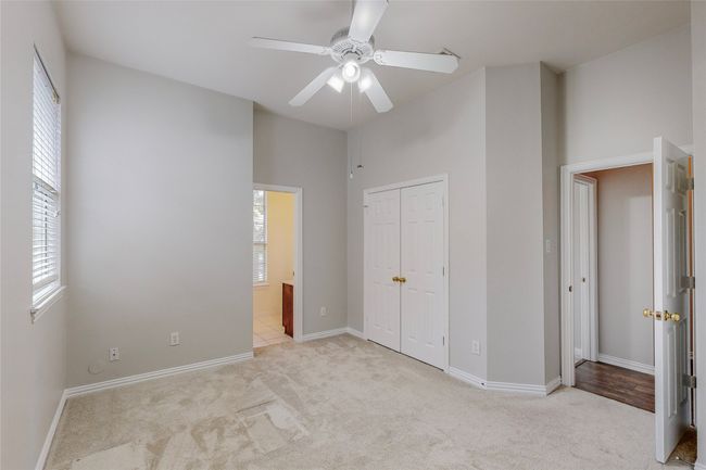 Unfurnished bedroom featuring light colored carpet, a closet, baseboards, and a ceiling fan | Image 35