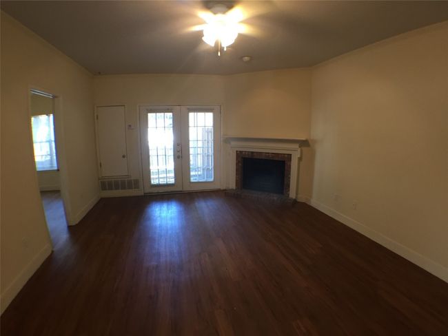 Unfurnished living room with baseboards, a fireplace, ceiling fan, and dark wood-style flooring | Image 9