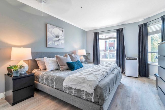 Bedroom featuring light wood-type flooring, multiple windows, and crown molding | Image 17