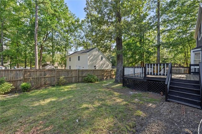 Fenced backyard with a deck and view of scattered trees | Image 41