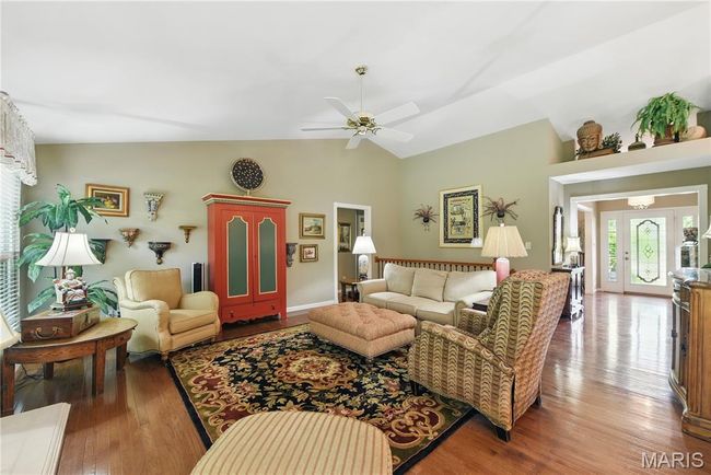 Living area featuring ceiling fan, wood finished floors, and high vaulted ceiling | Image 5