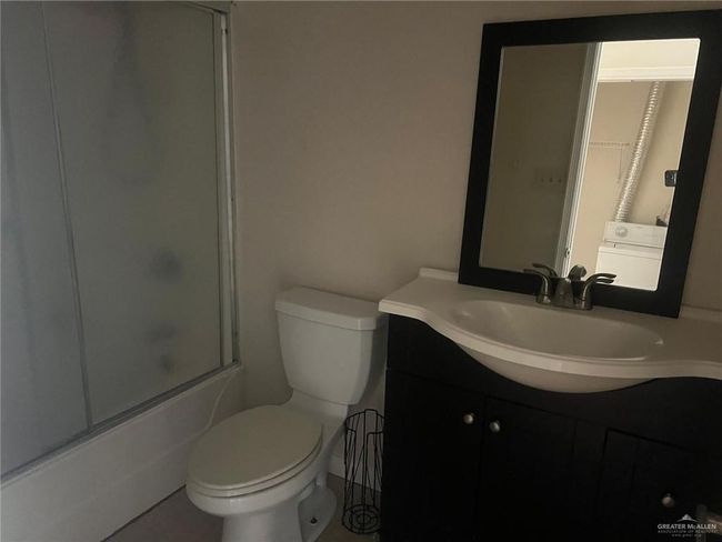Full bath with vanity, shower / bath combination with glass door, and tile patterned flooring | Image 7