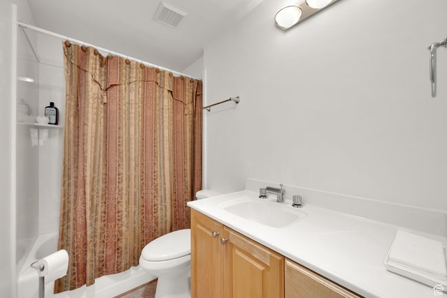Bathroom featuring toilet, shower / bath combination with curtain, and vanity | Image 18