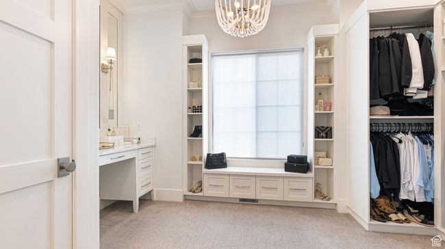 Spacious closet with light colored carpet, a notable chandelier, and visible vents | Image 16