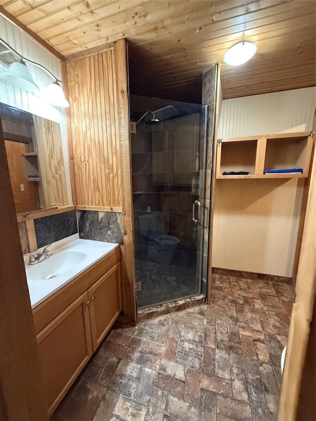 Full bathroom with vanity, wood ceiling, a shower stall, and brick patterned floors | Image 10