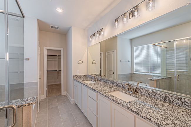 Bathroom with a shower stall, double vanity, tile patterned floors, a spacious closet, and a bath | Image 26