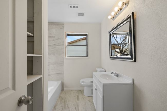 Bathroom with a tub, vanity, and toilet | Image 16