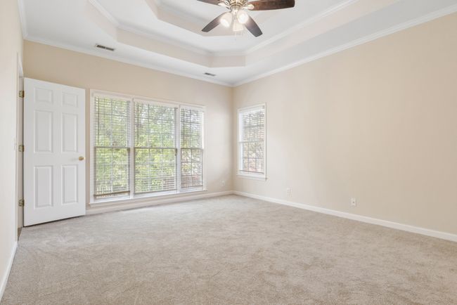 Primary has tray ceiling, new lighting, fresh paint, new carpet, and lovely diffused natural light from backyard window. | Image 16