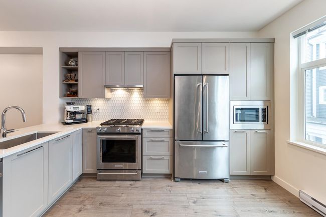 Kitchen with appliances with stainless steel finishes, baseboard heating, and gray cabinets | Image 10