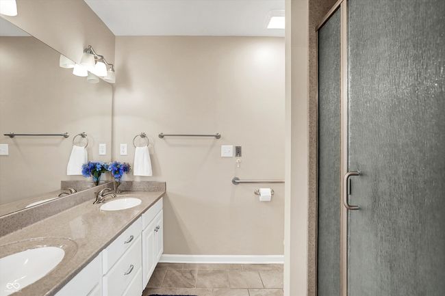 Master bathroom featuring double vanity, a shower stall, and baseboards | Image 25