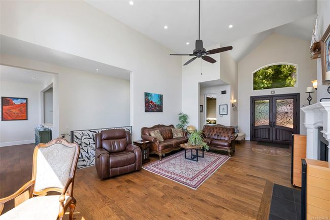 Living area with wood finished floors, high vaulted ceiling, a ceiling fan, and recessed lighting | Image 44