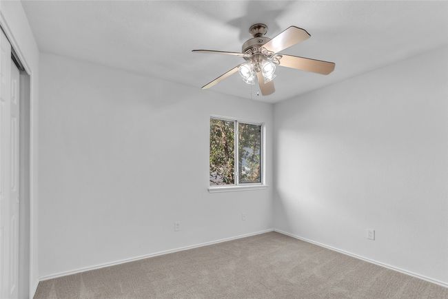 Carpeted empty room featuring ceiling fan and baseboards | Image 25
