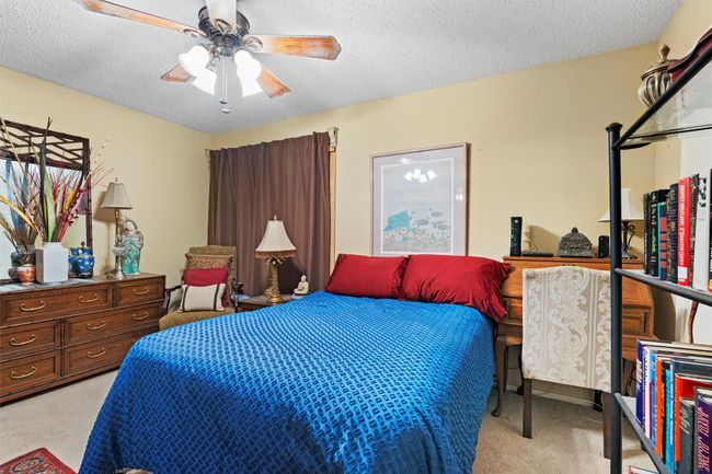Bedroom with ceiling fan, a textured ceiling, and light carpet | Image 22