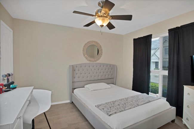 Bedroom with wood finished floors, ceiling fan, baseboards, and multiple windows | Image 6