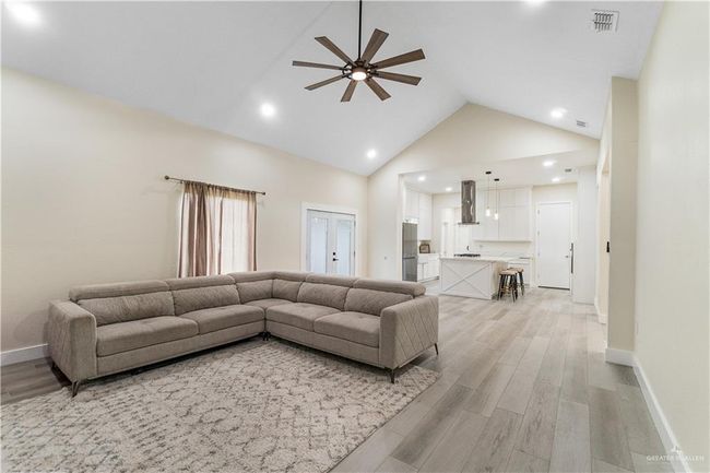 Living room with high vaulted ceiling, ceiling fan, and light hardwood / wood-style floors | Image 20