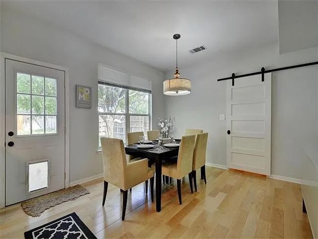 Dining space with a barn door, plenty of natural light, and light wood-style flooring | Image 13