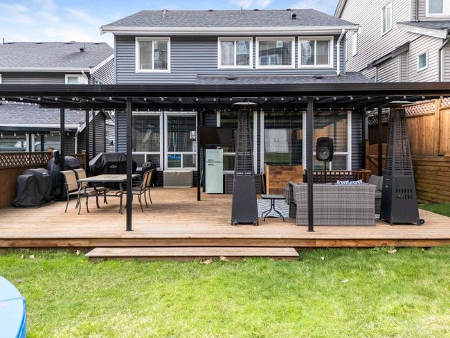 Rear view of property featuring a shingled roof, a yard, and fence | Image 17