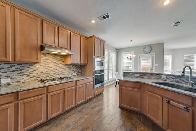 Kitchen featuring a sink, appliances with stainless steel finishes, and under cabinet range hood | Image 14