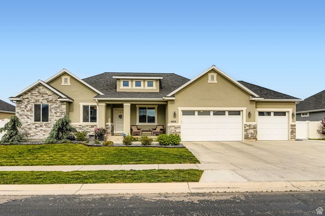 View of front of house with stone siding, stucco siding, a porch, an attached garage, and driveway | Image 27