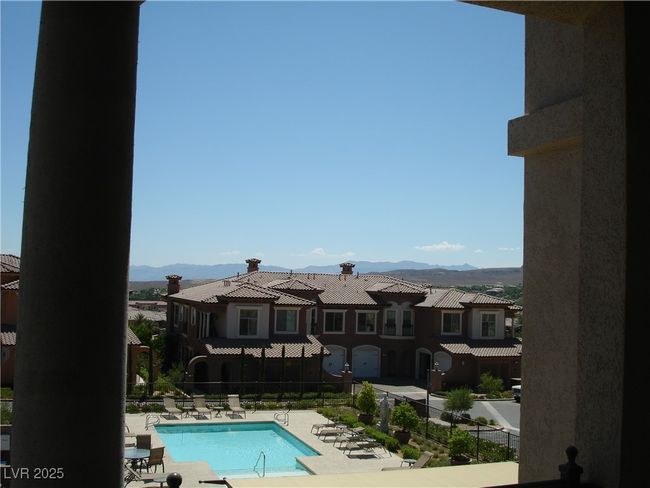 Community pool with a mountain view and a patio | Image 12