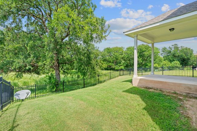 Fenced backyard featuring a patio and view of wooded area | Image 32