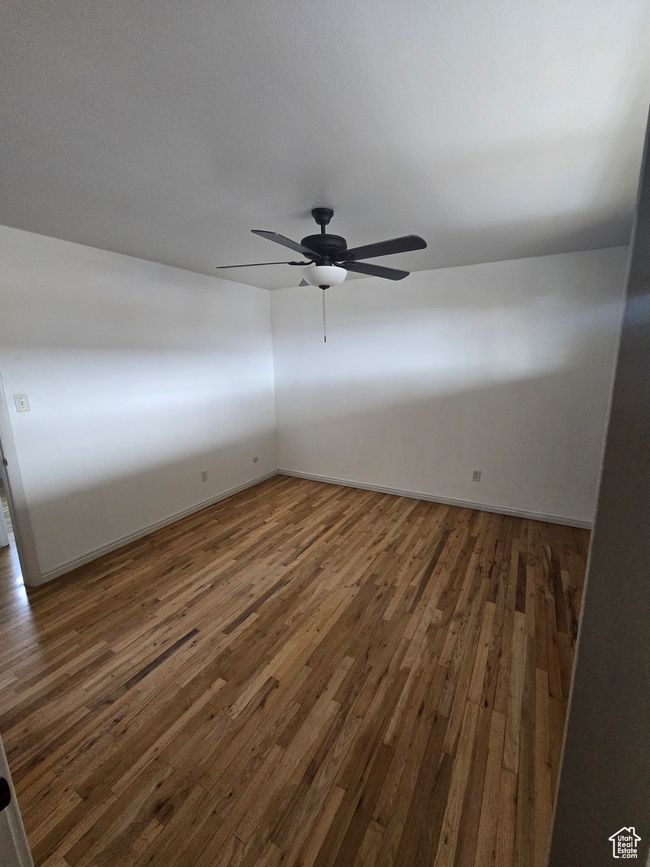 Spare room featuring wood finished floors and ceiling fan | Image 9