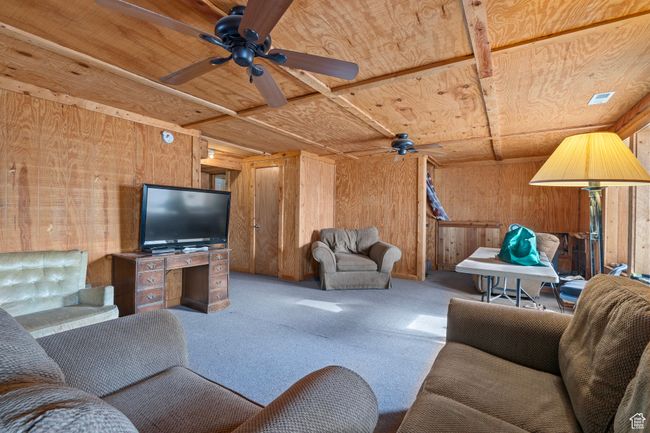 Living room with carpet flooring, wooden walls, and wood ceiling | Image 9