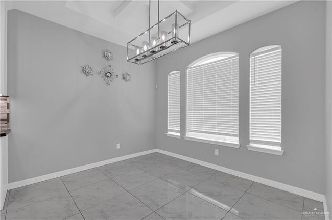 Unfurnished dining area with marble finish flooring and a chandelier | Image 9
