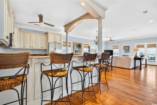 Kitchen with cream cabinetry, ceiling fan, refrigerator with ice dispenser, ornate columns, and recessed lighting | Image 10