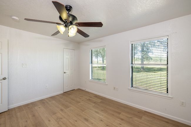 Spare room with light wood-style flooring, a ceiling fan, and baseboards | Image 14