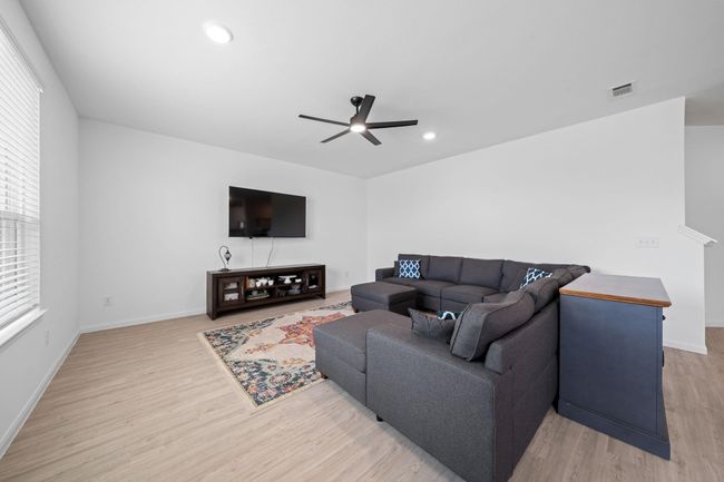 The living area features a ceiling fan and sits adjacent to the kitchen and dining spaces, enhancing the open-concept design. | Image 13