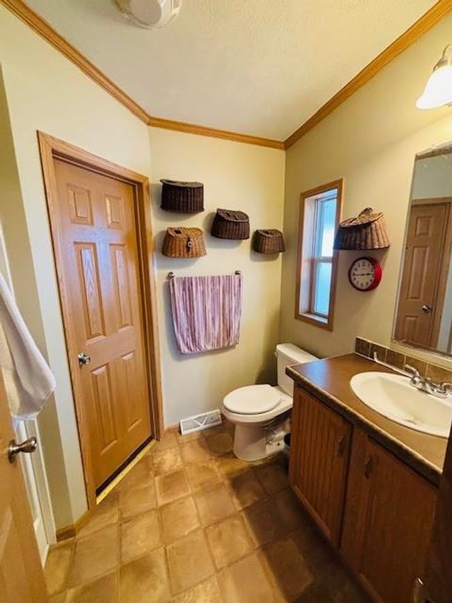 Half bath featuring vanity, ornamental molding, a textured ceiling, toilet, and visible vents | Image 15