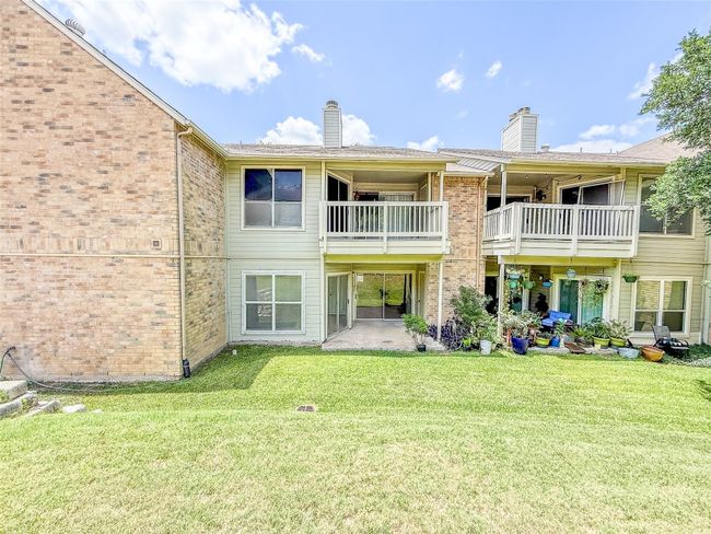 Back of property with a chimney, a balcony, brick siding, and a yard | Image 13