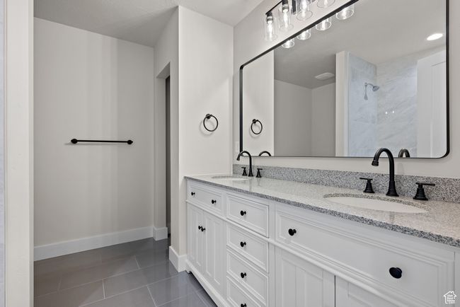 Bathroom featuring double vanity, tile patterned flooring, and a tile shower | Image 27