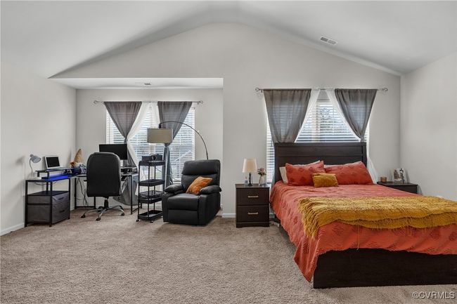 Bedroom with carpet floors, baseboards, vaulted ceiling, and visible vents | Image 9