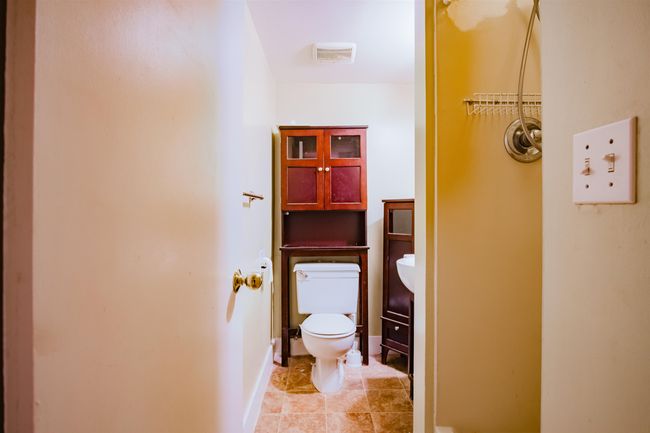 Bathroom with toilet, tile patterned flooring, visible vents, and baseboards | Image 26