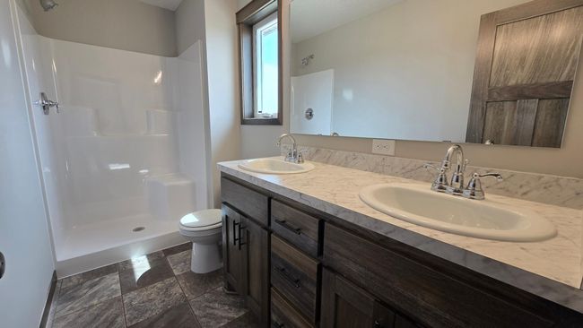 The primary 3/4 bath offers a double sink vanity, 3x4 fiberglass shower bay and a single casement window. | Image 19