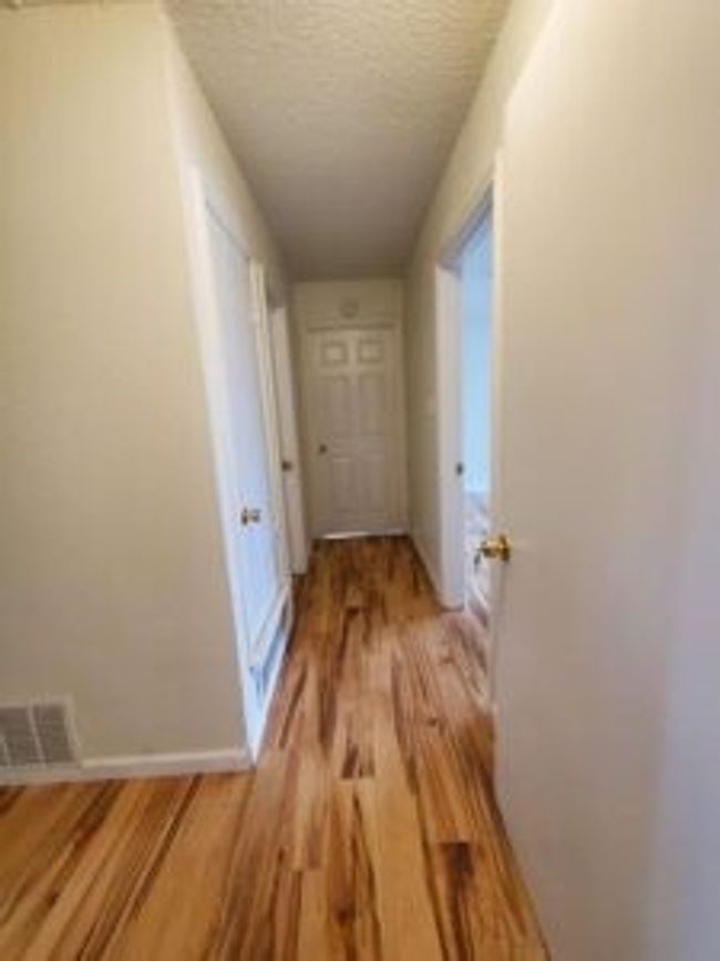 Hallway featuring light wood-type flooring and a textured ceiling | Image 34