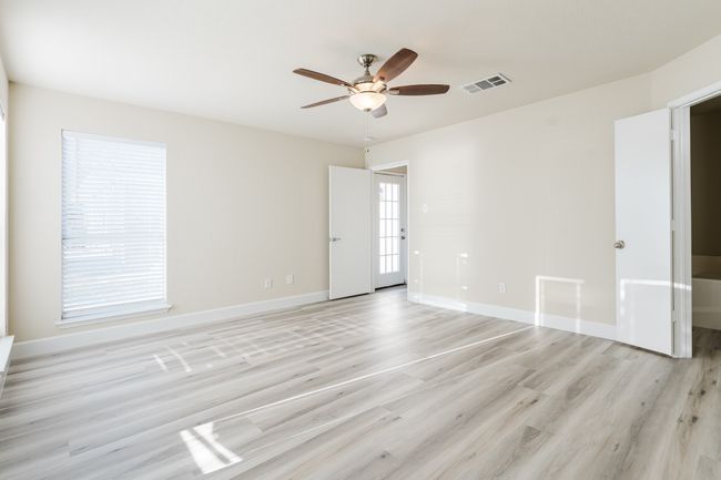 Unfurnished room with light wood finished floors, baseboards, visible vents, and ceiling fan | Image 9