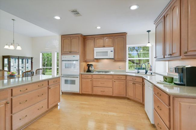 The kitchen was thoughtfully updated in 2014 with quartz countertops and engineered wood flooring. | Image 7