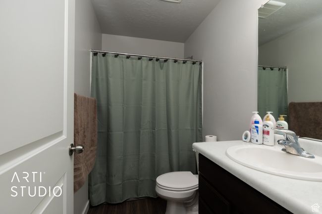 Full bathroom featuring wood finished floors, vanity, toilet, and a shower with curtain | Image 24