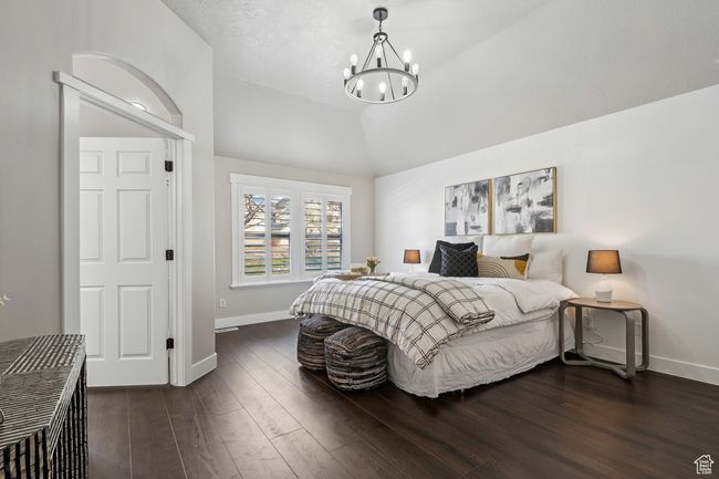 Bedroom featuring lofted ceiling, dark hardwood / wood-style flooring, and a chandelier | Image 15